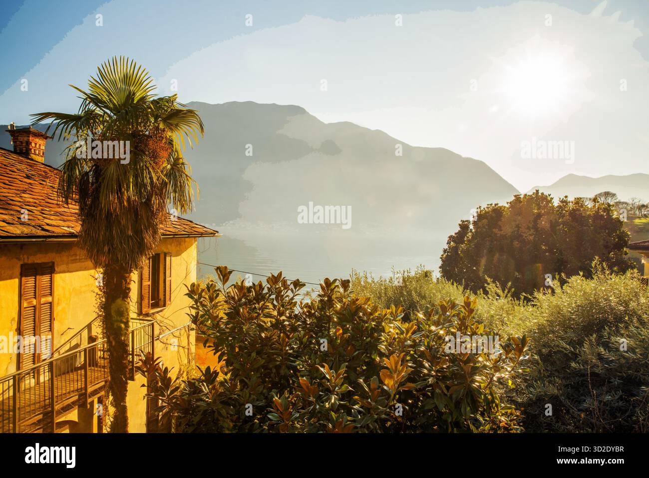 Verde e acqua del lago di Como e parte di casa gialla e Alpi europee . Ora Natale. Mi fischio con uno studente cinese lungo la costa Foto Stock