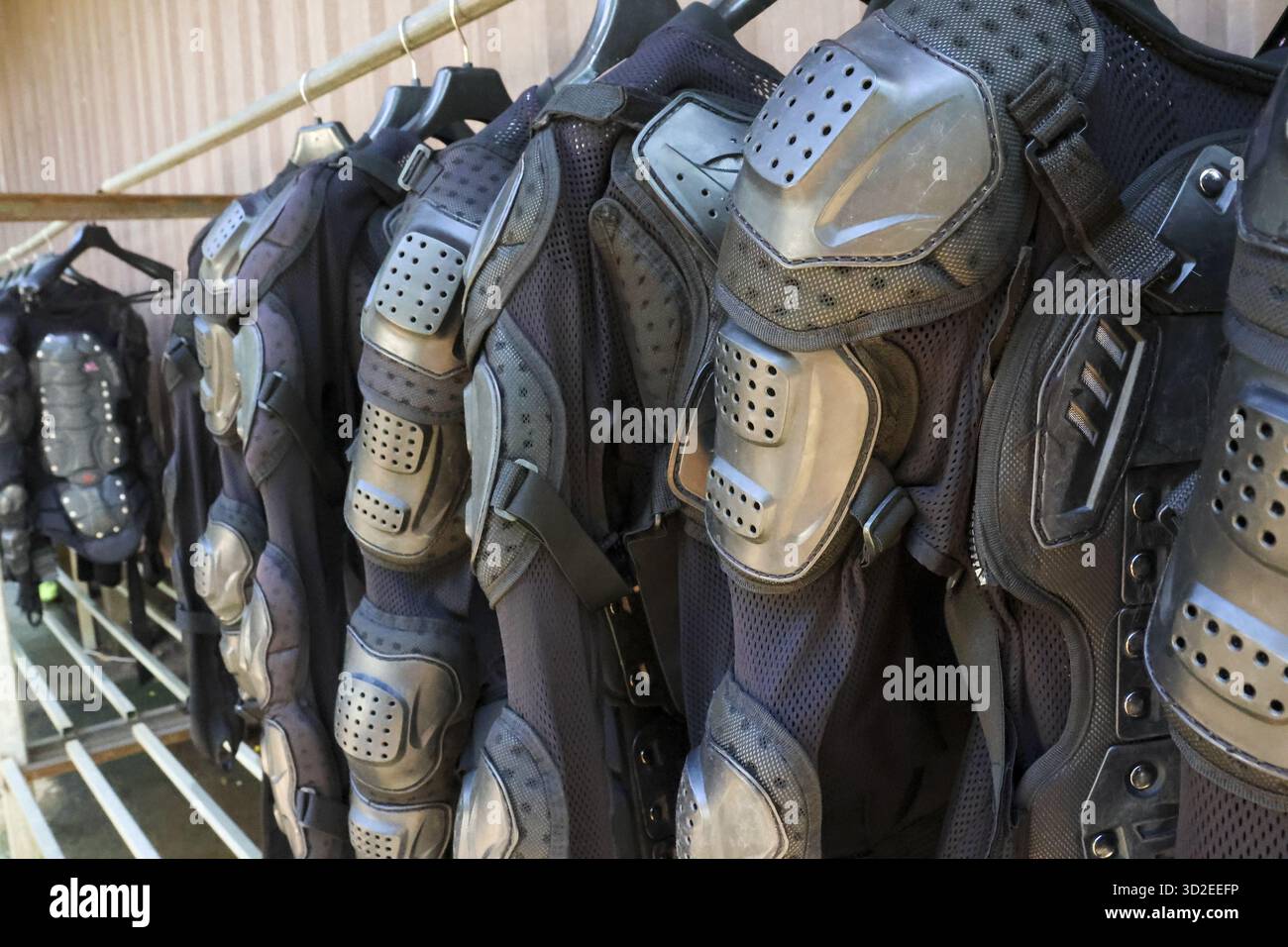 Fila di equipaggiamento di protezione tattico per le armature sul rack. l'attrezzatura protettiva per motocross o sport estremi trasmette senso di prontezza e potenza Foto Stock