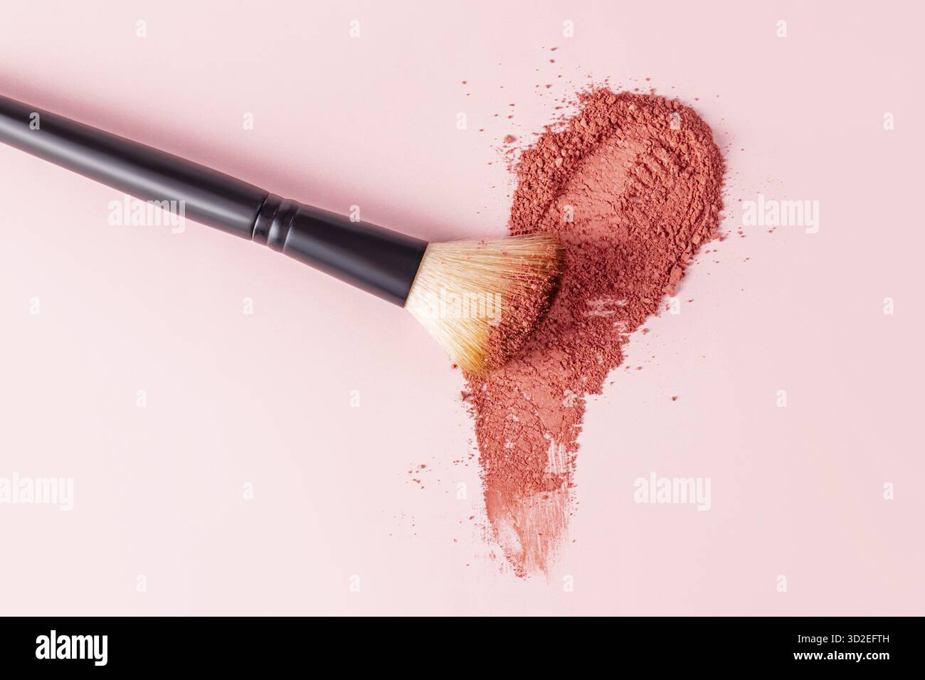 Un'elegante spazzola per il trucco si appoggia su un campione di colore blush sciolto con un tono universale. sfondo pastello. Uno spazio di copia. Vista dall'alto. Layout, design del prodotto Foto Stock