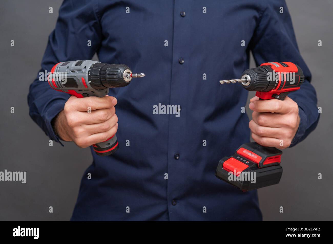 Due cacciaviti a batteria nelle mani degli uomini Foto Stock