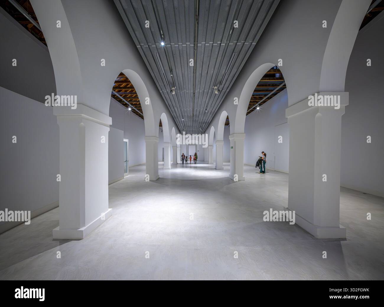 I visitatori ammirano la miscela di archi bianchi e travi a vista nelle Atarazanas, che mostrano l'atmosfera storica del patrimonio culturale di Siviglia. Foto Stock