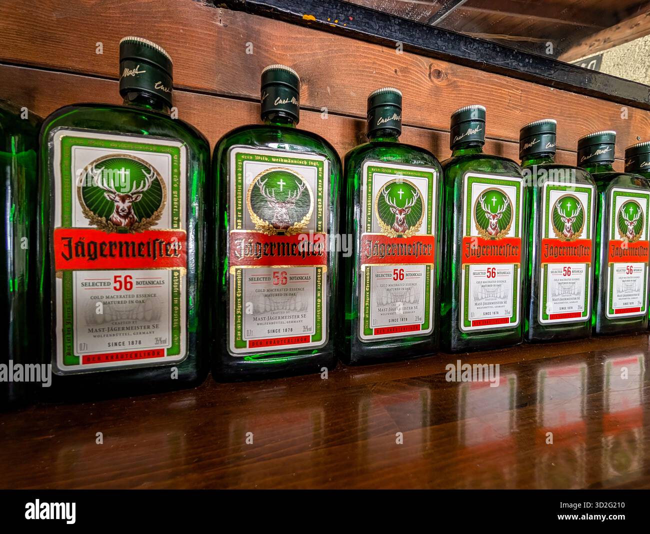 Molti flaconi Jägermeister allineati su Un bancone in legno. Atmosfera da night bar Foto Stock