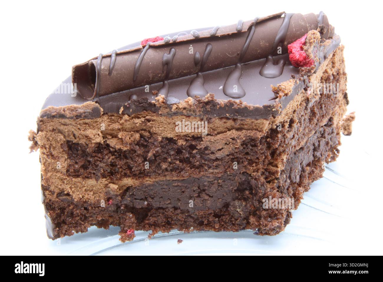 Primo piano di una fetta di torta al cioccolato multistrato. Gli strati di torta con spugna scura e mousse di crema al cioccolato sono chiaramente visibili. Il dessert è d Foto Stock
