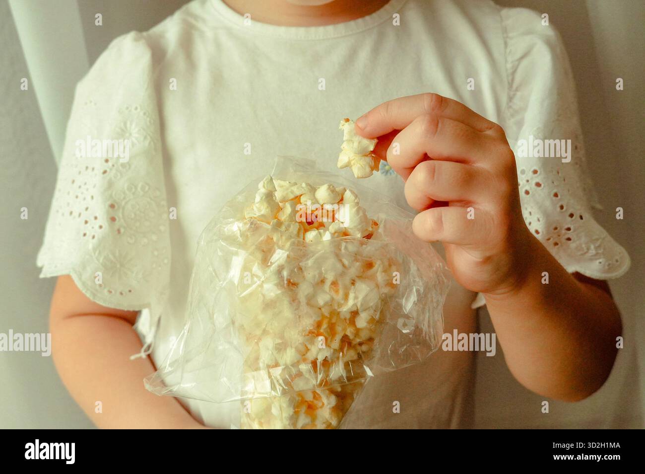Bambino che mangia popcorn a casa. Messa a fuoco selettiva. Ragazzo. Cibo. Foto Stock