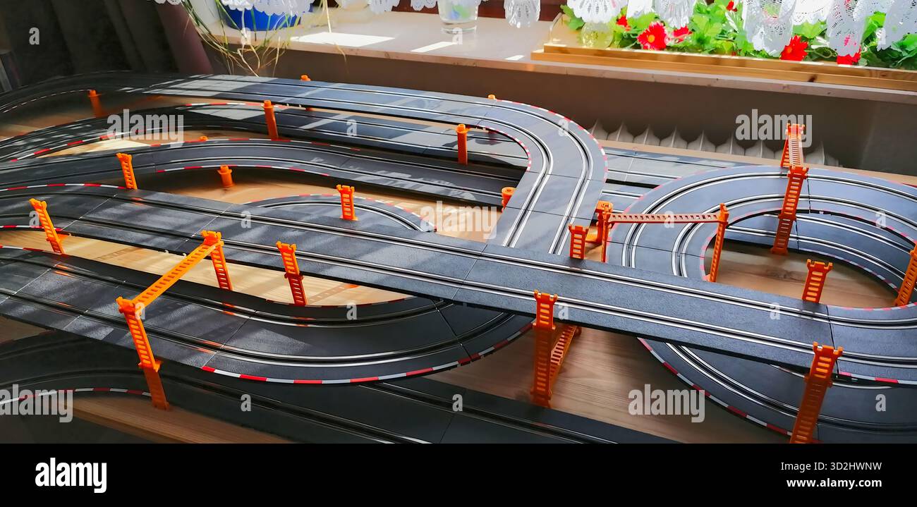 Vista parziale della pista privata di una slot car con sezioni di ponte sopraelevate, creando una dinamica scena di corse in miniatura. Foto Stock