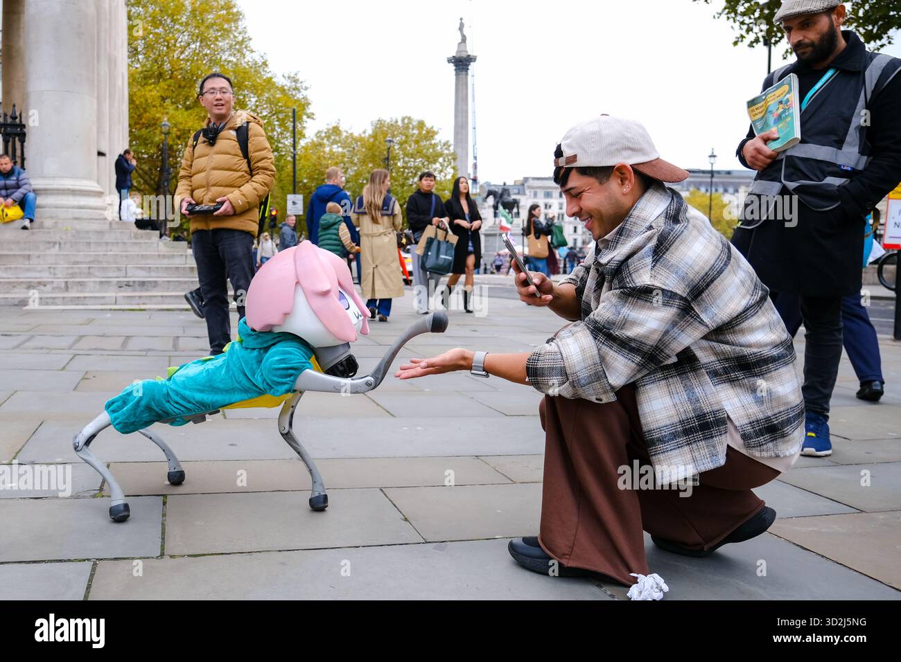 Londra, Regno Unito. 1 novembre 2025. Un cane robot bionico quadruplo vestito con un cappotto verde e una parrucca rosa viene portato fuori per una passeggiata dal suo proprietario vicino a Trafalgar Square, attirando sguardi sconcertati e una serie di reazioni da parte di persone che camminavano, si sedevano e si stendevano. Credito: Fotografia dell'undicesima ora/Alamy Live News Foto Stock