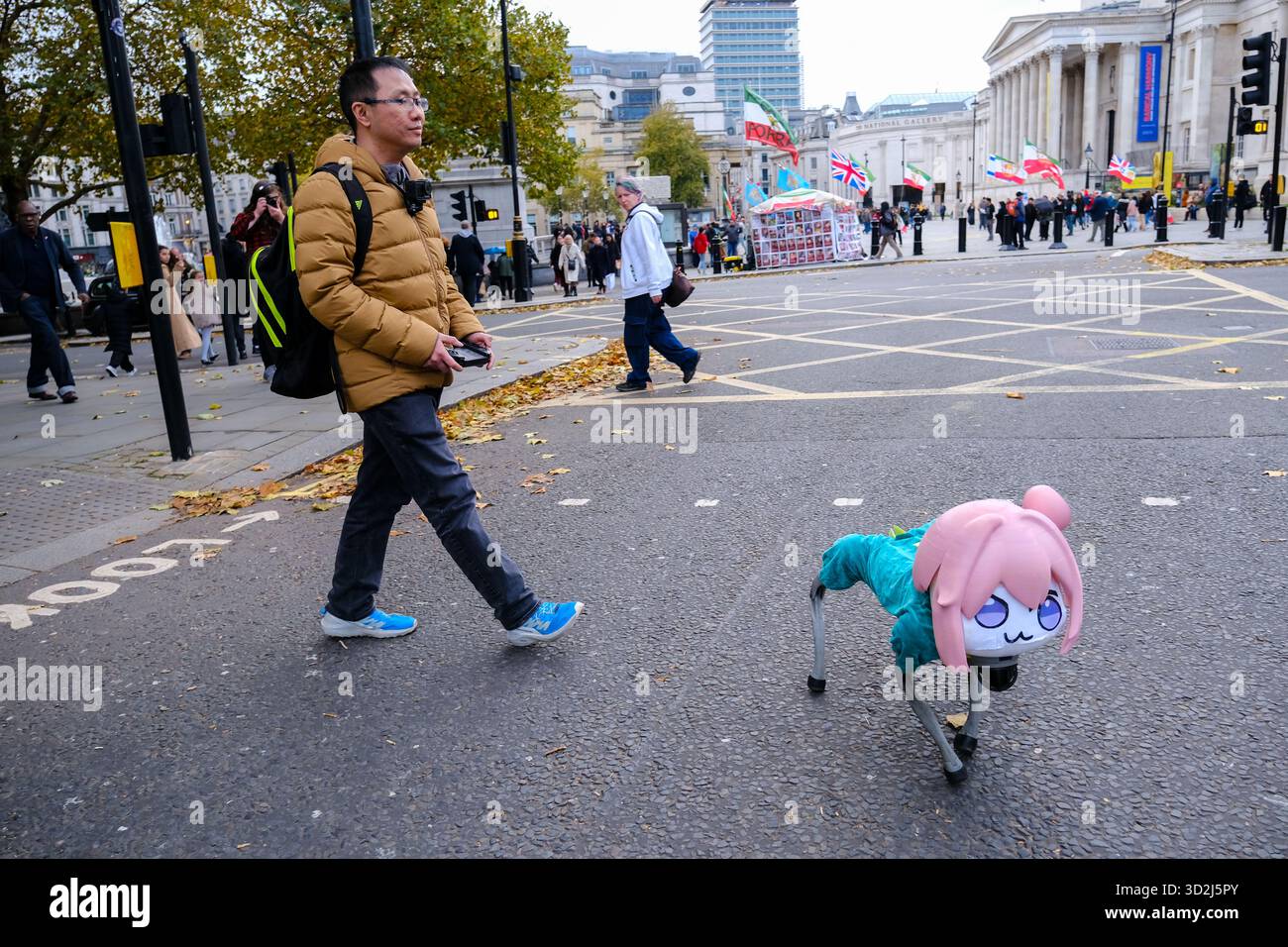 Londra, Regno Unito. 1 novembre 2025. Un cane robot bionico quadruplo vestito con un cappotto verde e una parrucca rosa viene portato fuori per una passeggiata dal suo proprietario vicino a Trafalgar Square, attirando sguardi sconcertati e una serie di reazioni da parte di persone che camminavano, si sedevano e si stendevano. Credito: Fotografia dell'undicesima ora/Alamy Live News Foto Stock