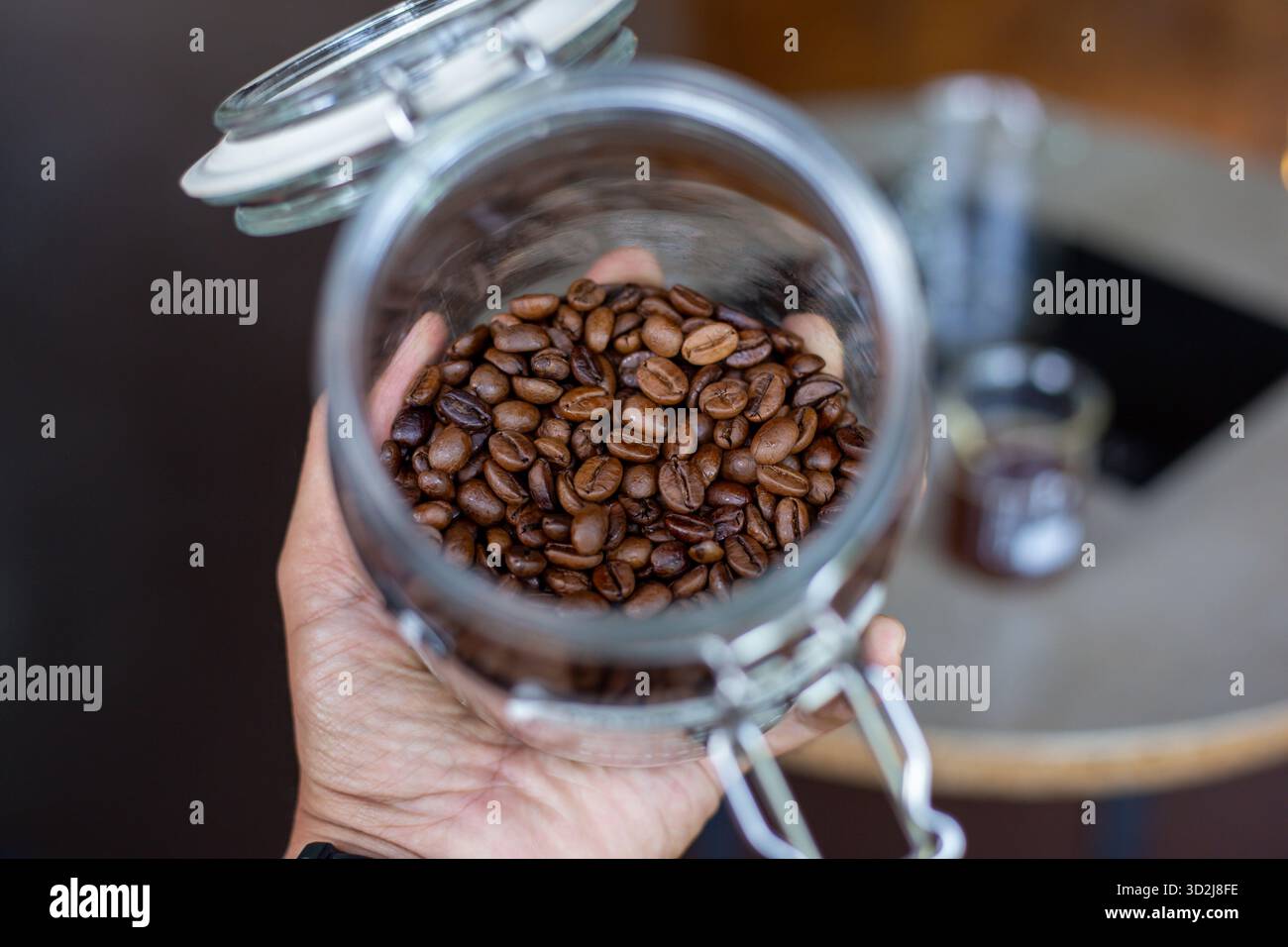 Messa a fuoco selettiva, chicchi di caffè di buona qualità, lucido, marrone scuro in un vaso di vetro. Foto Stock
