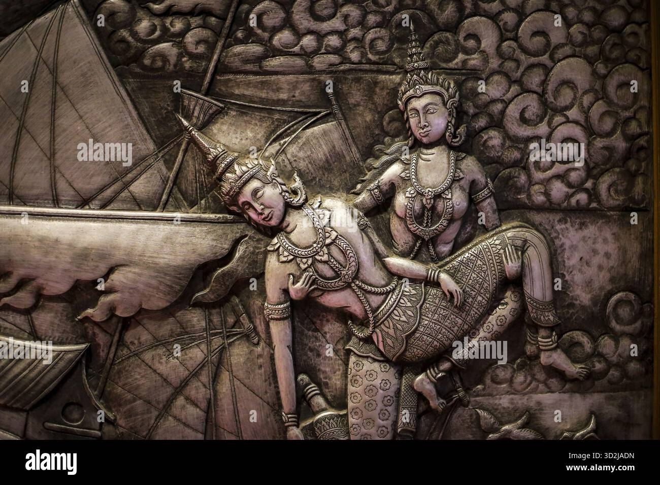 L'antica scultura in bassorilievo raffigura una narrazione drammatica della mitologia culturale. Una figura ornata di abbigliamento tradizionale mostra profondo dolore, sostenuto da anot Foto Stock