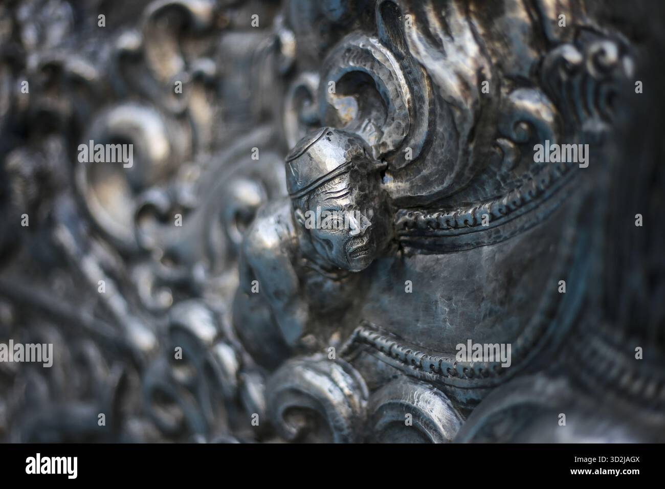 Scultura in metallo argentato decorato che mostra un antico design barocco, con un volto dettagliato e una raffinata maestria artigianale. un pezzo storico irradia una a sfarzosa Foto Stock