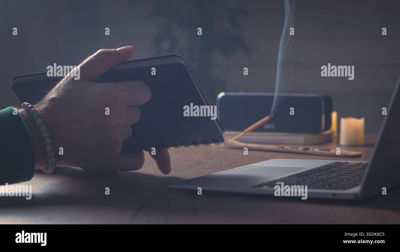 Silenzio cinematografico. Una scena calda e luminosa in casa, con un computer desktop, un notebook e un delicato fumo di incenso che scorre attraverso l'aria: Calma e creatività Foto Stock