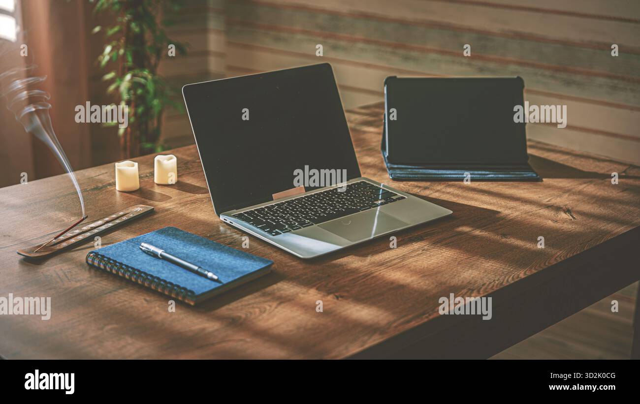 Produttività a caldo. Elegante angolo ufficio con computer desktop, notebook, levetta profumata e luci simili a una candela, musica tranquilla grazie all'altoparlante Bluetooth Foto Stock