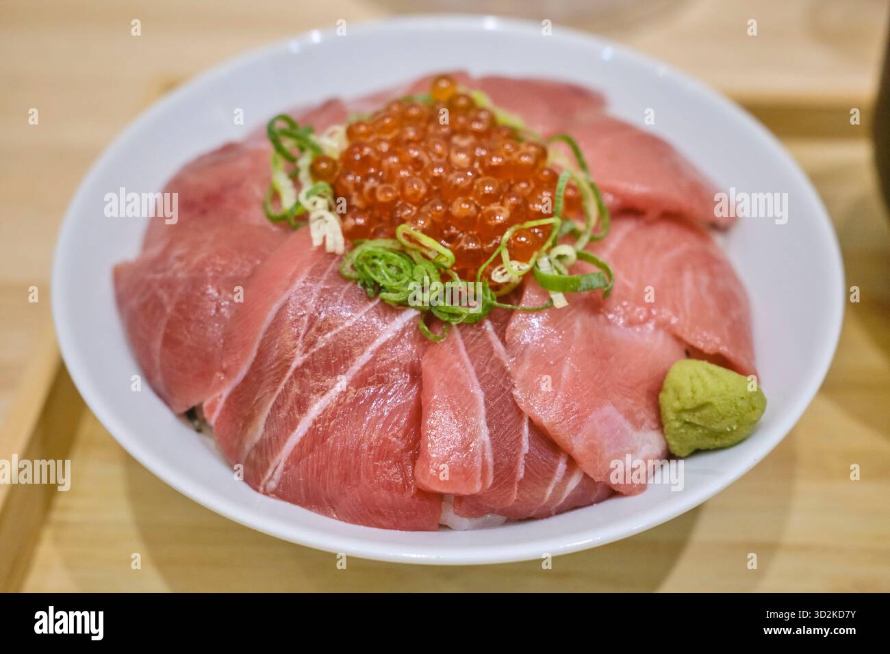 Una ciotola di riso con sashimi di tonno condita con uova di salmone e wasabi in Giappone Foto Stock