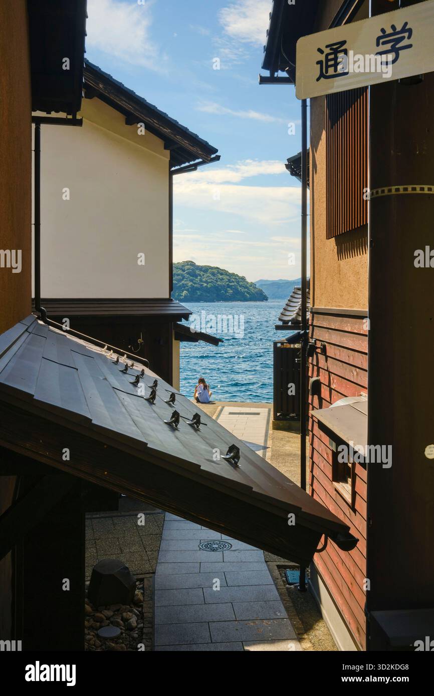 Persona non identificata seduta a guardare il Mar del Giappone al villaggio di pescatori Ine Foto Stock
