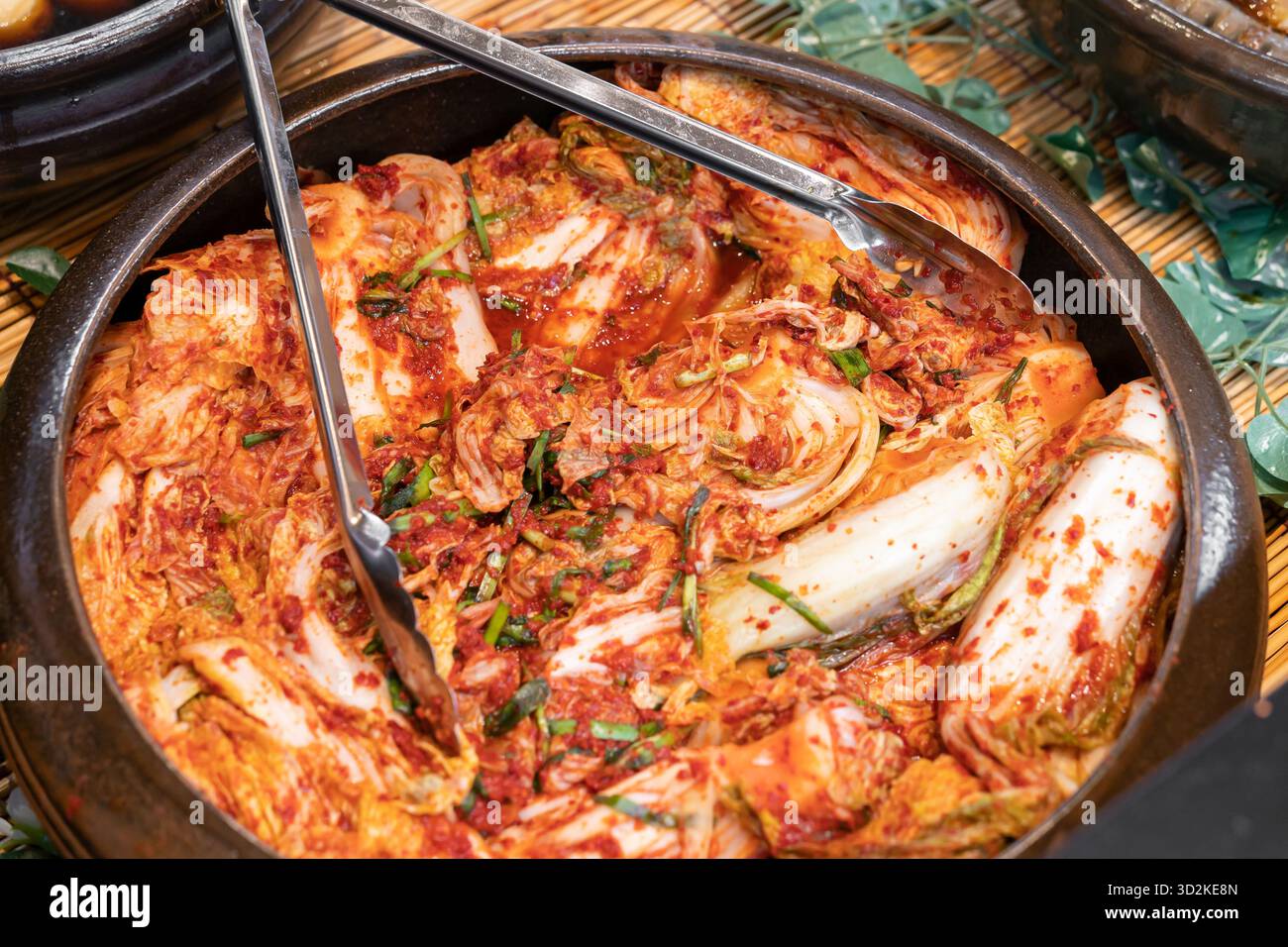 Tradizionale kimchi di cavolo coreano Napa fatto con scaglie di peperoncino, aglio, zenzero e salsa di pesce, fermentato per sviluppare un ricco sapore speziato. Foto Stock
