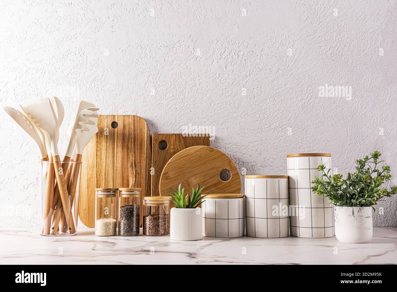 Elegante e moderno sfondo della cucina con articoli ecologici e utensili da cucina realizzati con materiali naturali. conservazione in ceramica . taglieri in legno Foto Stock