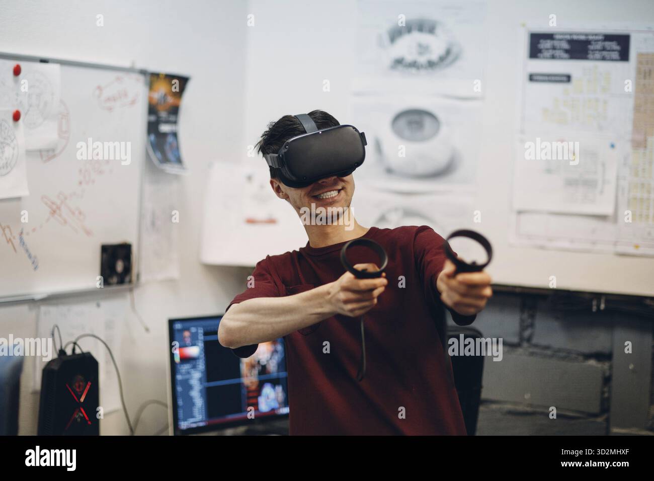 Giocatore giovane in occhiali per realtà virtuale, visore per occhiali VR con joystick Foto Stock