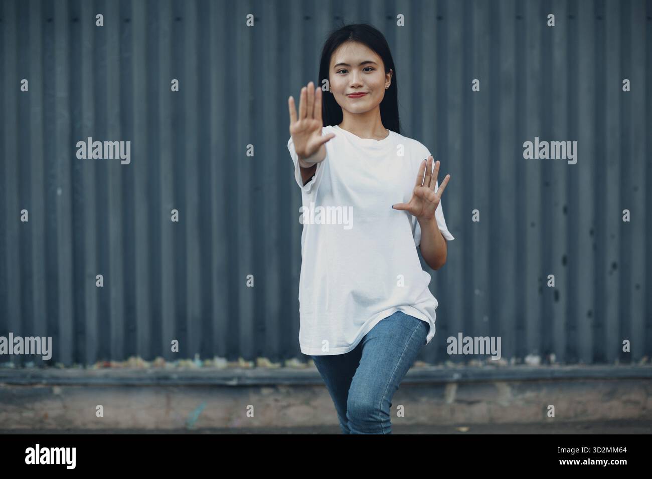 Giovane donna asiatica facendo esercizio di qigong parete esterna estate Foto Stock