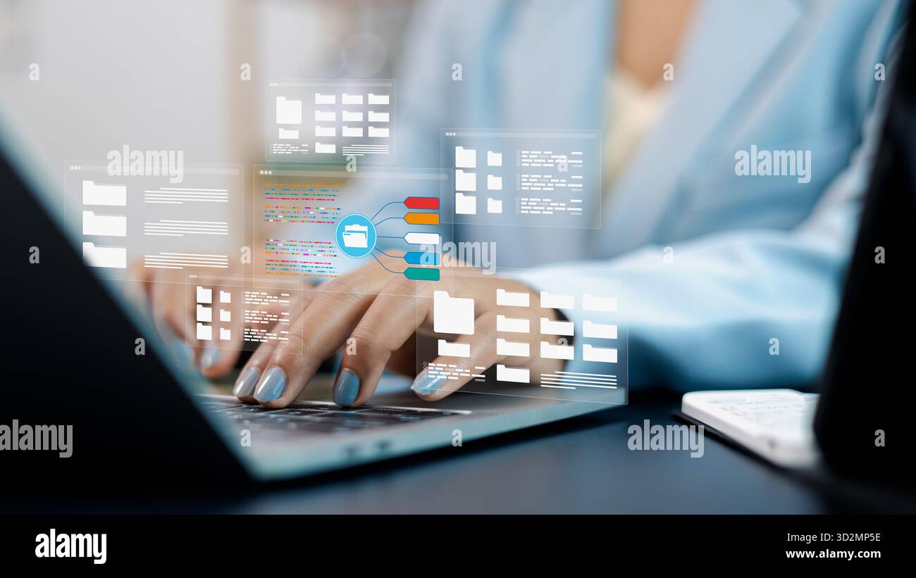 Persona aziendale che utilizza un laptop con ologramma delle cartelle di file digitali, che rappresenta lo storage su cloud, la gestione dei dati, il sistema informativo e la tecnologia moderna Foto Stock