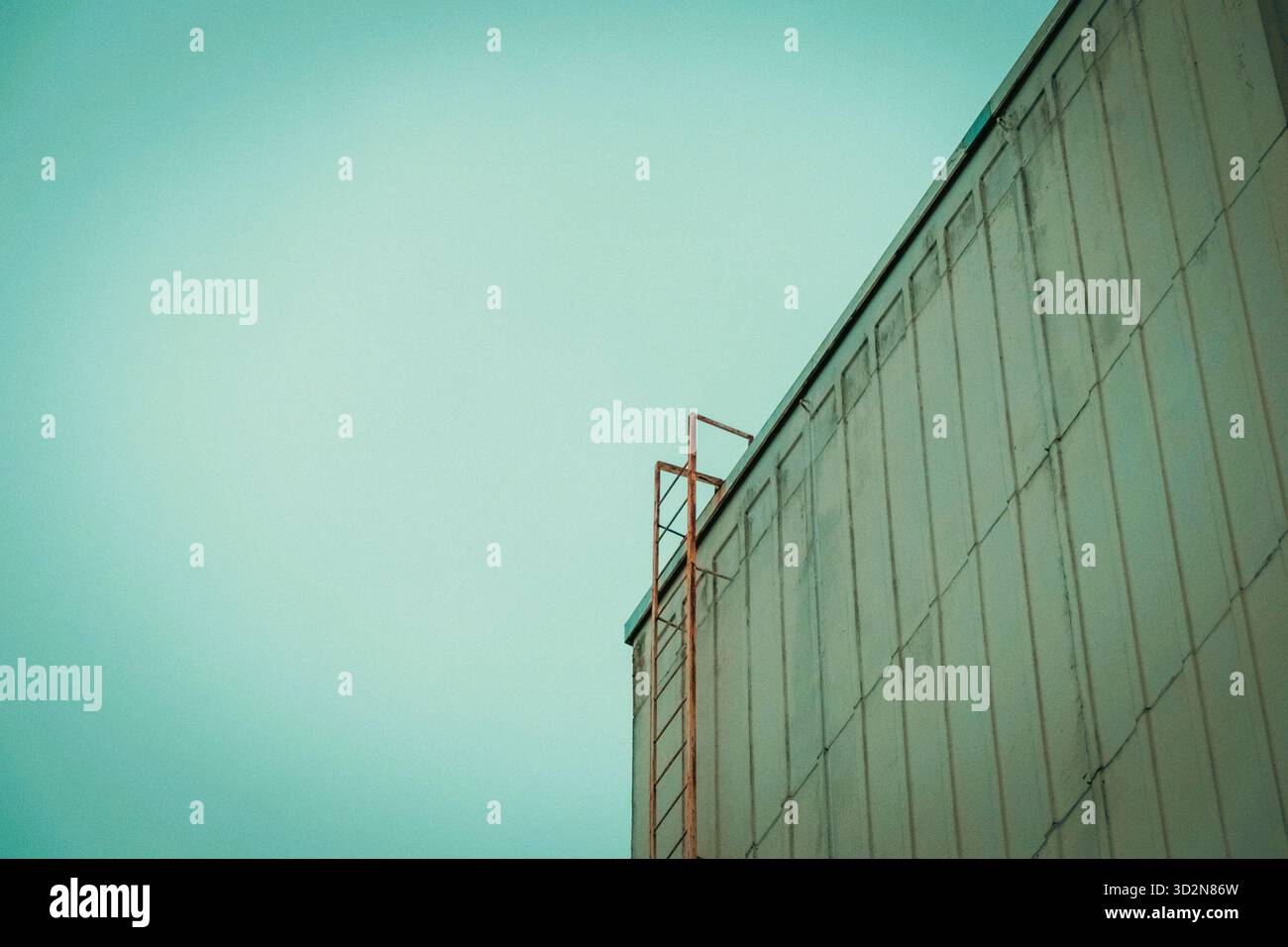 Edificio industriale minimalista con scala sul tetto sotto il cielo di tè Foto Stock