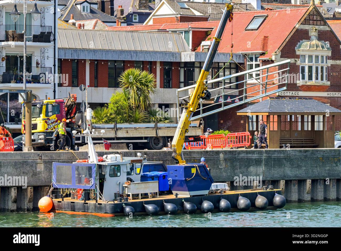 Dartmouth, Devon, Inghilterra, Regno Unito - 24 aprile 2025: Piccola imbarcazione industriale con gru idraulica sul ponte che carica una struttura sul ponte sul fiume Foto Stock