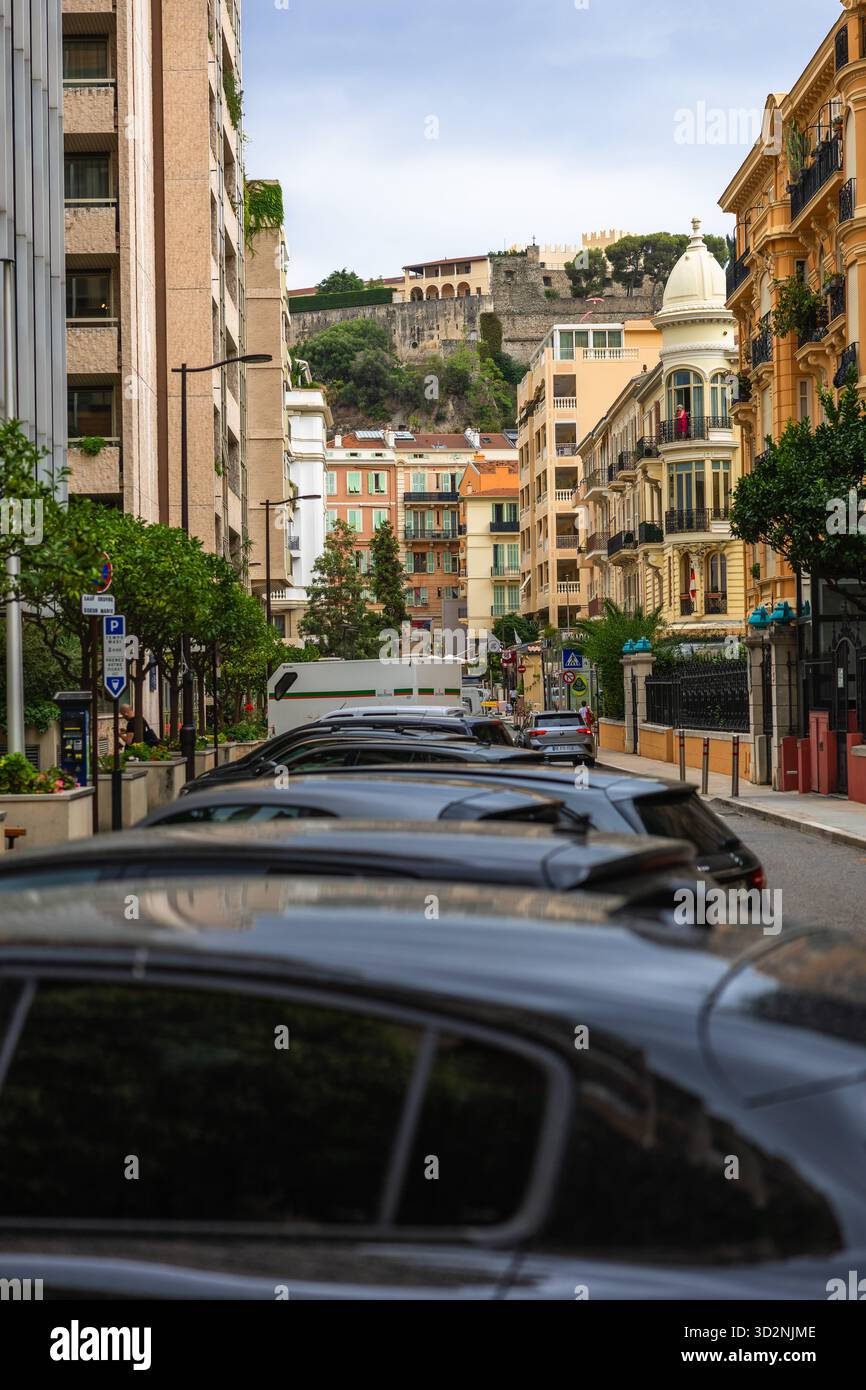 28.08.2025 Monaco. Una lussuosa facciata dell'hotel di Monaco con auto di lusso e personale in uniforme sulla strada, sullo sfondo di un alto edificio moderno Foto Stock
