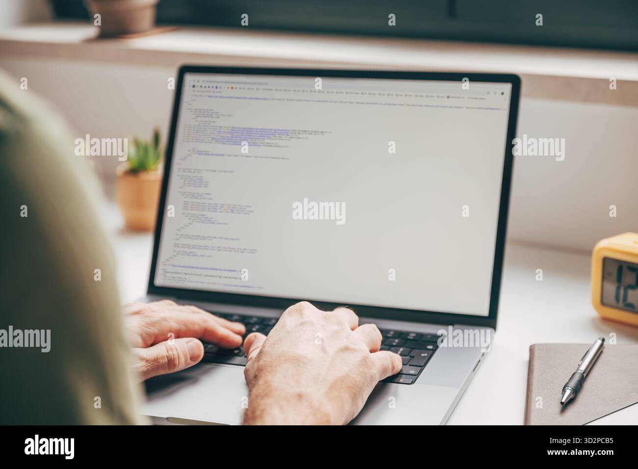 Primo piano di mani maschili che digitano il codice su un computer portatile in ufficio domestico, concetto di programmazione, sviluppo software e lavoro digitale remoto. Selettivo Foto Stock
