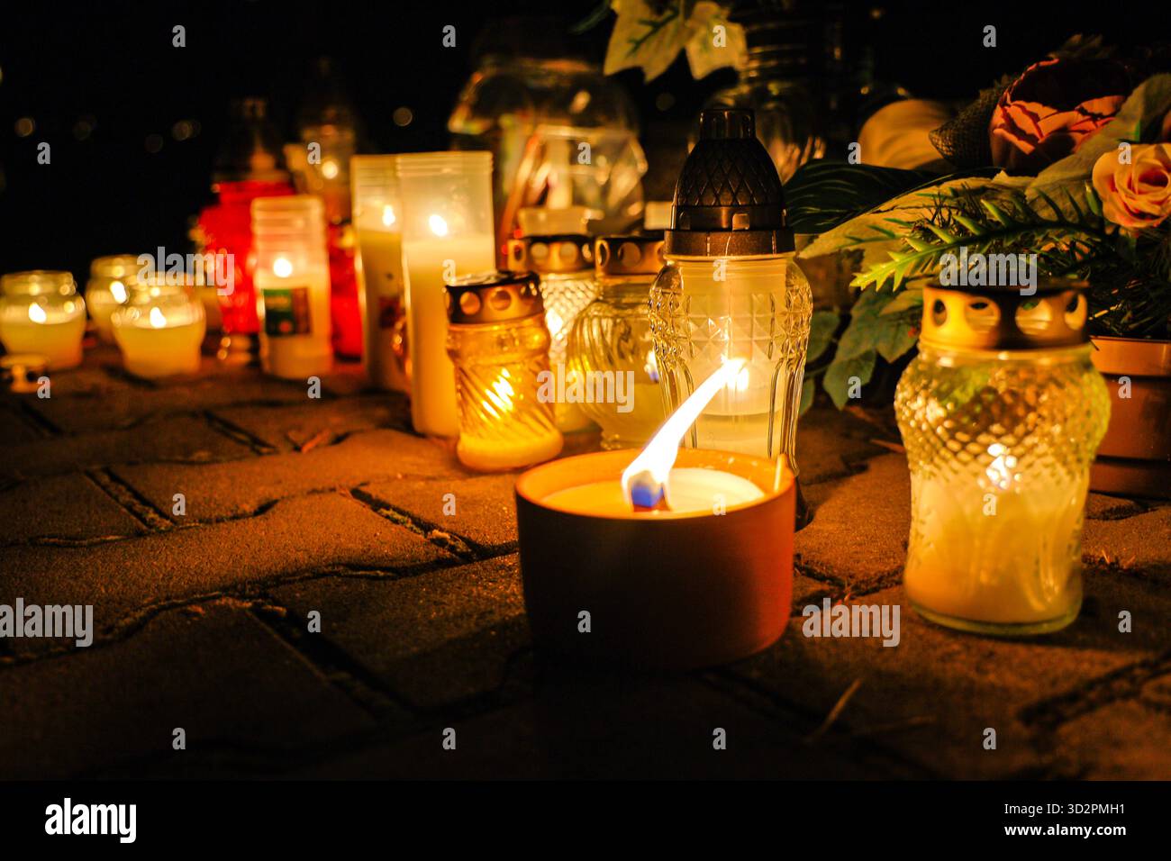 Candele e lanterne del giorno di Ognissanti al memoriale del cimitero, sfondo notturno in Polonia Foto Stock