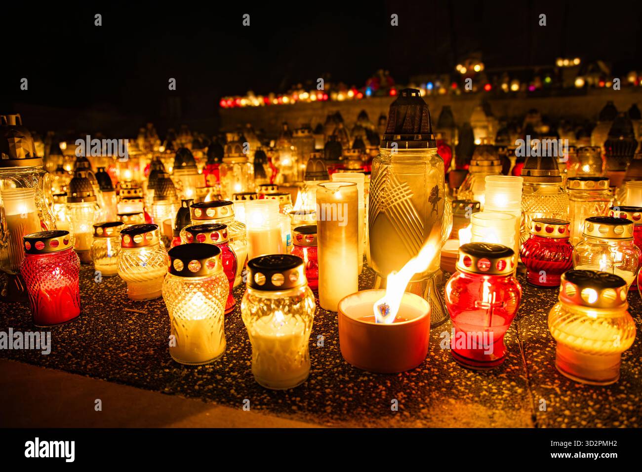 Candele e lanterne del giorno di Ognissanti al memoriale del cimitero, sfondo notturno in Polonia Foto Stock