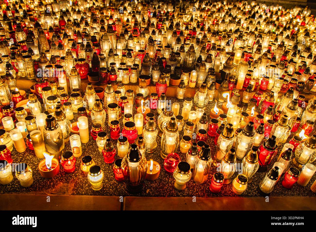 Candele e lanterne del giorno di Ognissanti al memoriale del cimitero, sfondo notturno in Polonia Foto Stock