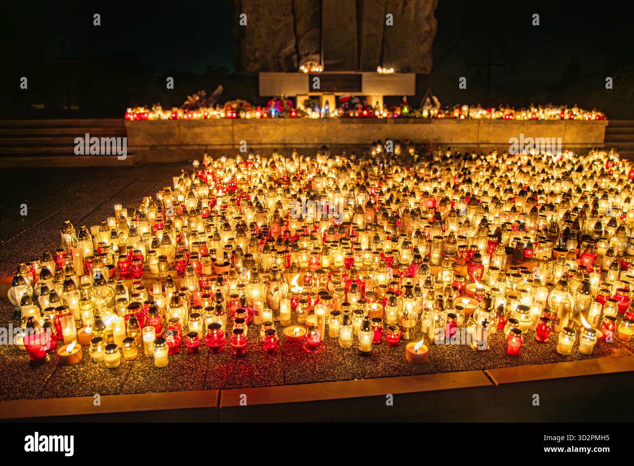 Candele e lanterne del giorno di Ognissanti al memoriale del cimitero, sfondo notturno in Polonia Foto Stock