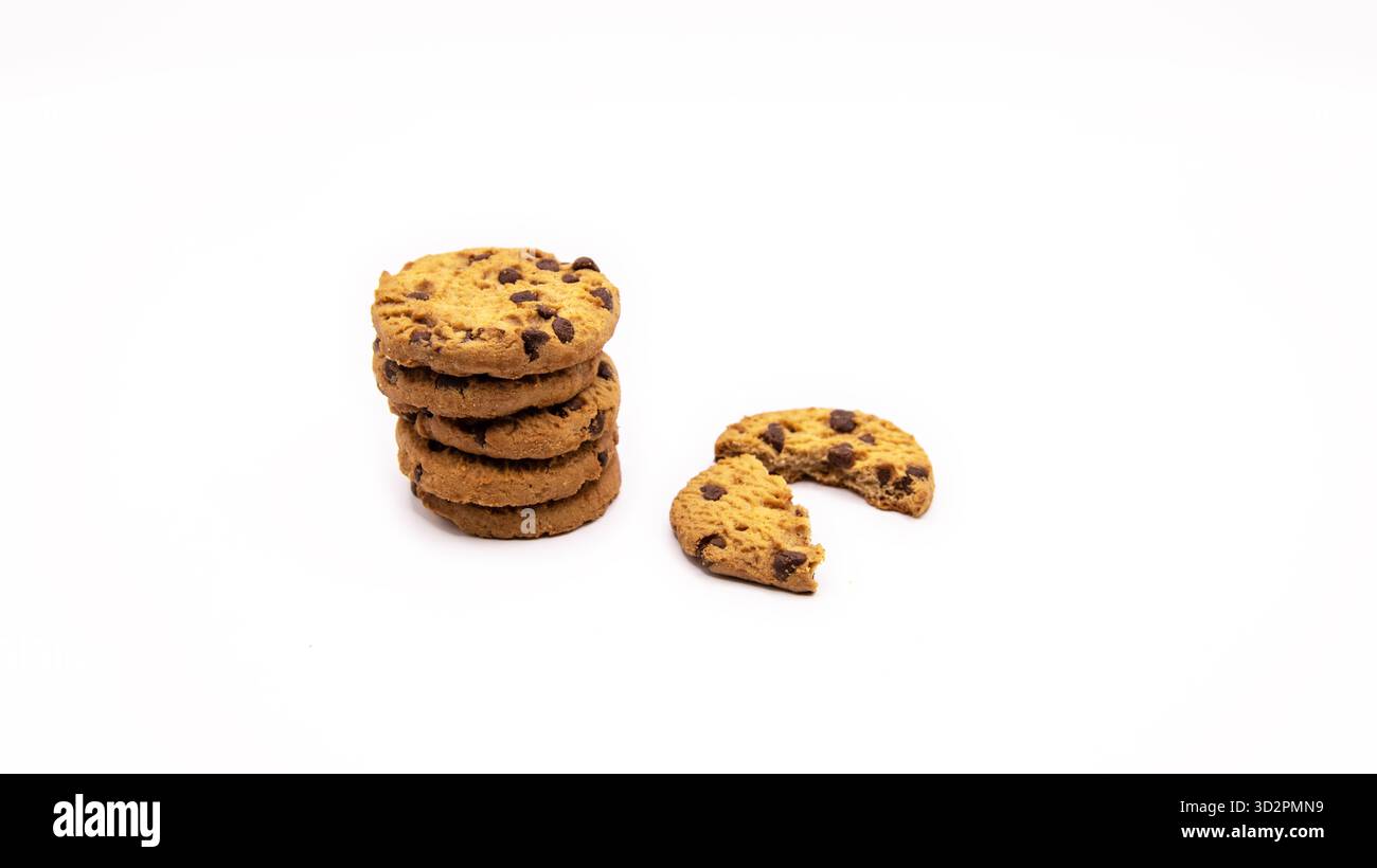 Biscotti con gocce di cioccolato appena sfornati impilati direttamente su uno sfondo bianco pulito. Minimalista e semplice fotografia di cibo per dessert o spuntini. Foto Stock