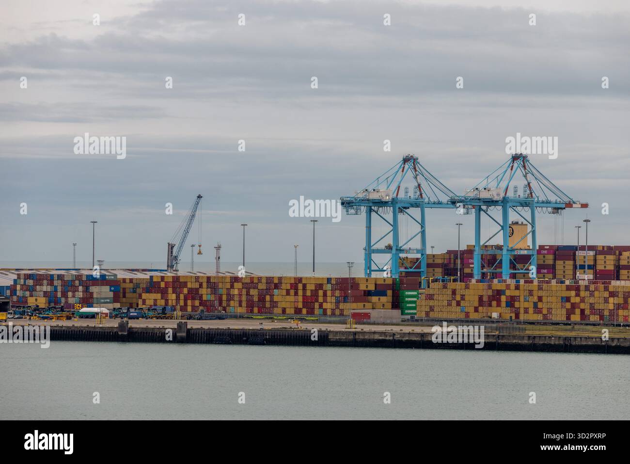 Contenitori di spedizione impilati presso il porto industriale per il trasporto merci globale Foto Stock