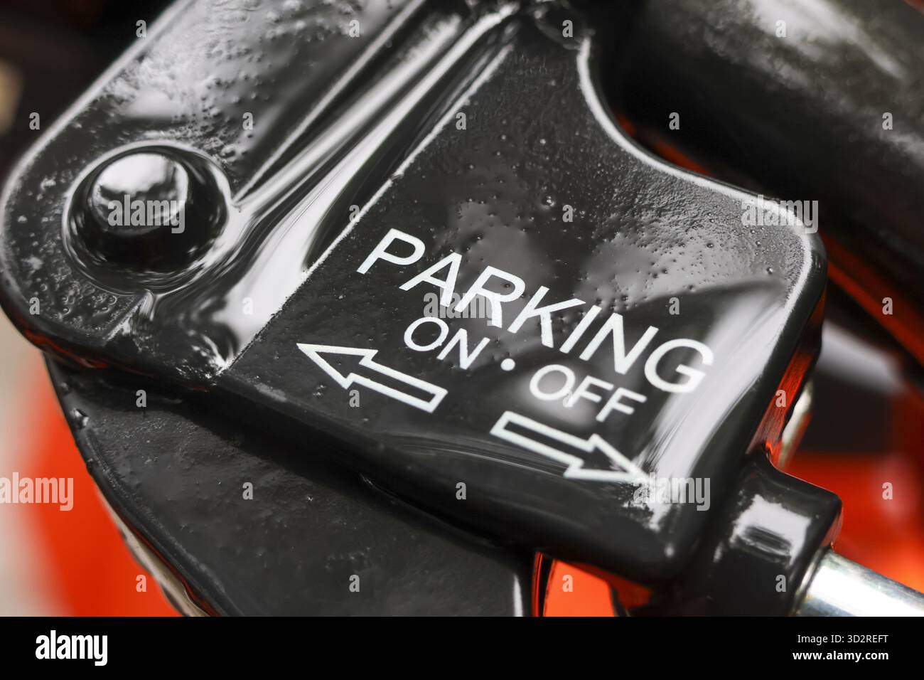Primo piano dell'interruttore della leva del freno di stazionamento in metallo nero che mostra l'accensione e lo spegnimento. parte meccanica per la sicurezza del veicolo, fornendo senso di sicurezza e controllo Foto Stock