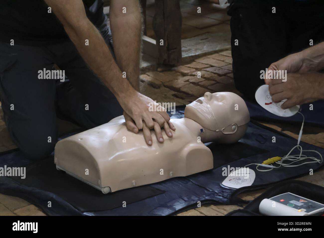 Apprendere le tecniche di rianimazione cardiopolmonare sul manichino di addestramento con particolare attenzione alle compressioni toraciche e al posizionamento degli elettrodi per defibrillazione semiautomatica questa dimostrazione di abilità salvavita evoca l'urgenza e. Foto Stock