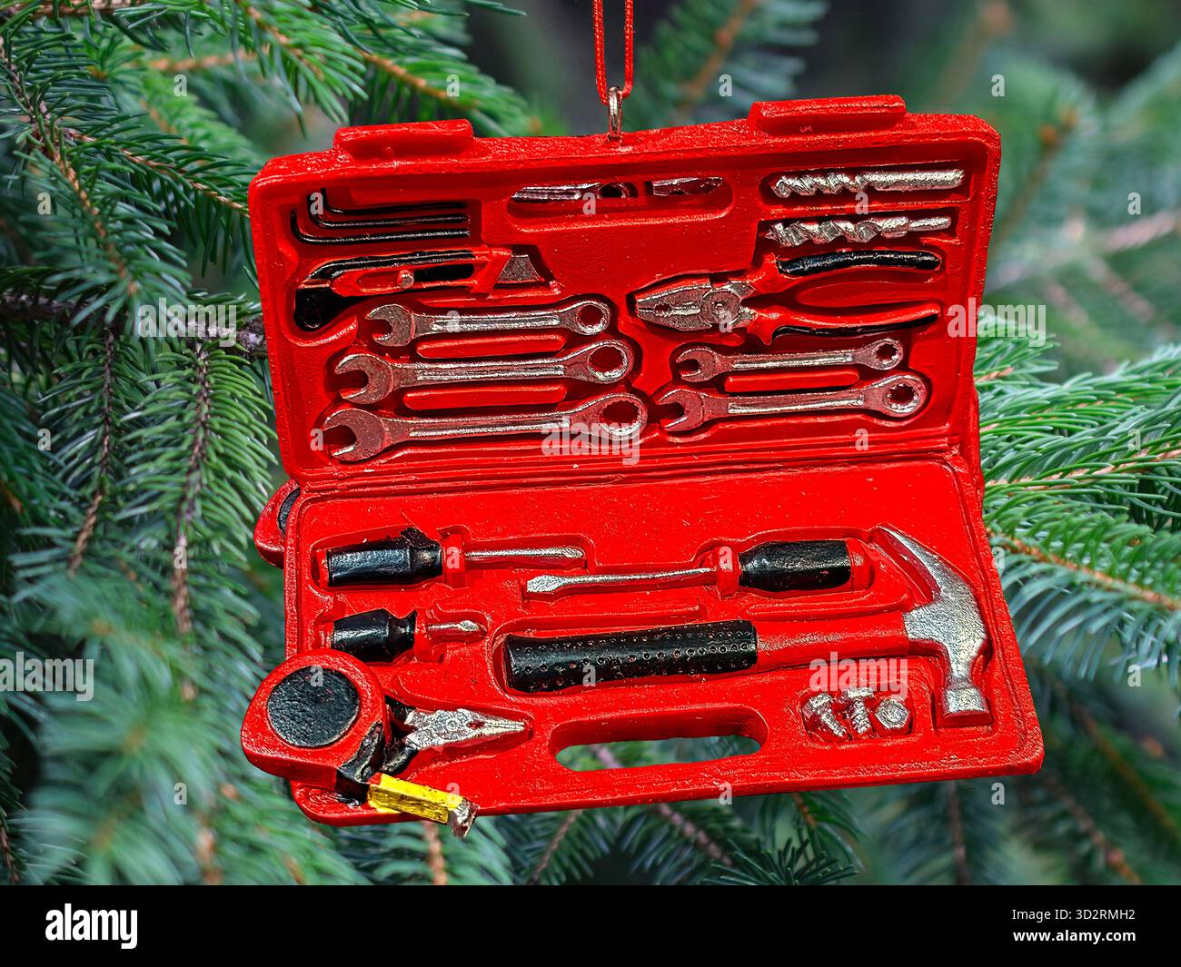 Ornamento natalizio con attrezzi per l'edilizia. Bulloneria per lavori di riparazione nel settore edile: Cacciavite, sega, trapano, martello, vite, morsetto Foto Stock