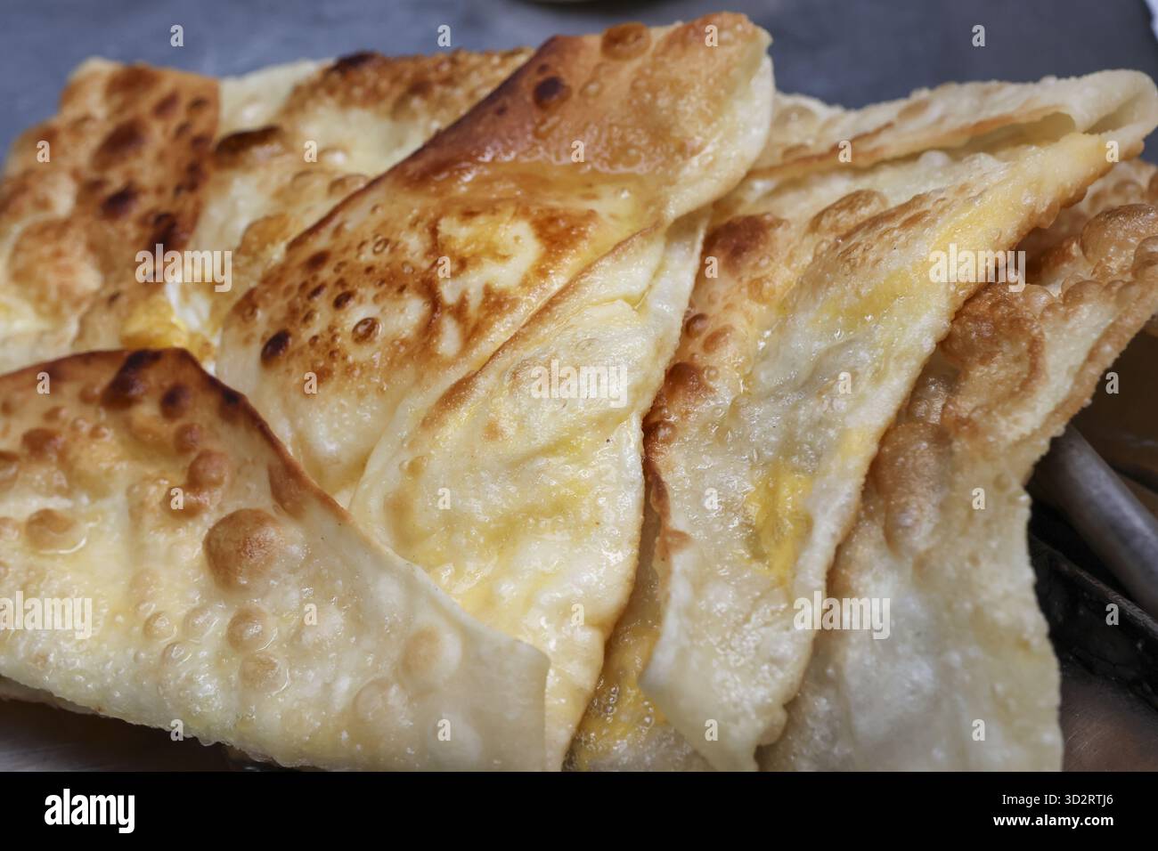Delizioso e appetitoso primo piano di Roti Canai marrone dorato. Saporita focaccia asiatica popolare per colazione in Malesia, con consistenza croccante e fla Foto Stock