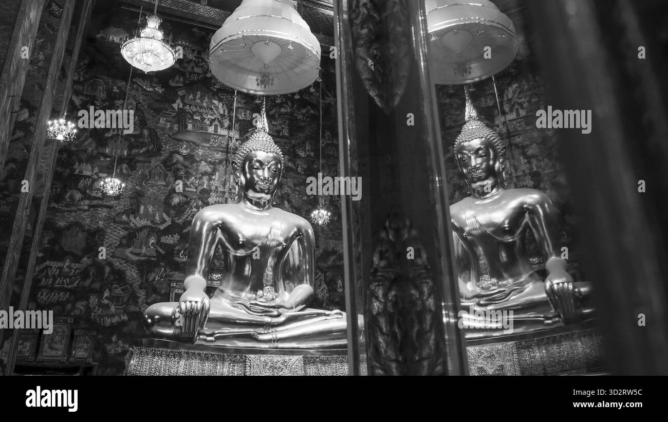 Serena vista in bianco e nero della statua dorata del Buddha nel tempio spirituale. Questa scultura sacra per la meditazione e la religione evoca un senso di calma e. Foto Stock