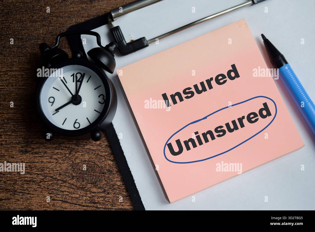 Concetto di cerchio blu non assicurato scrivere su note adesive isolate su un tavolo di legno. Foto Stock