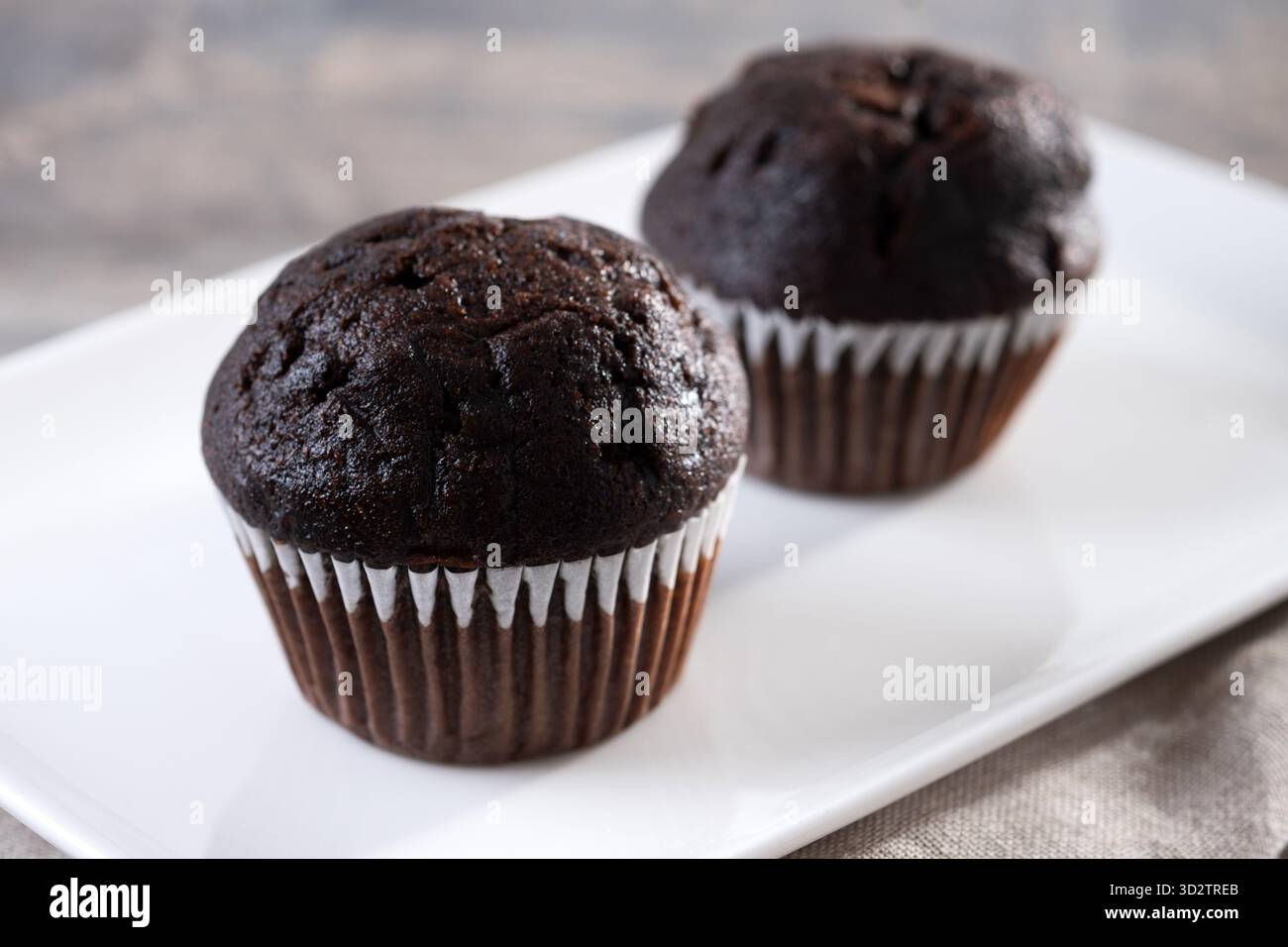 Muffin al cioccolato su un tavolo di legno Foto Stock