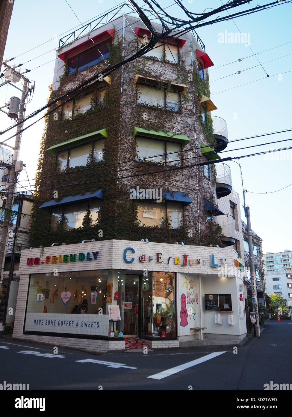 Mr. Friendly Café in un edificio d'angolo coperto di viti a Ebisu, Tokyo, in un pomeriggio di sole Foto Stock