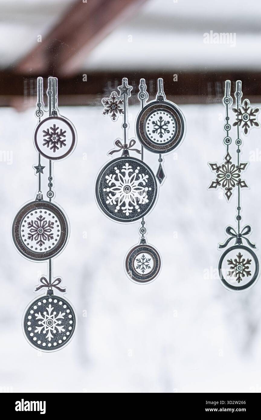Gli adesivi natalizi con fiocchi di neve e ornamenti natalizi creano un'atmosfera magica, perfetta per decorare gli spazi interni in inverno Foto Stock