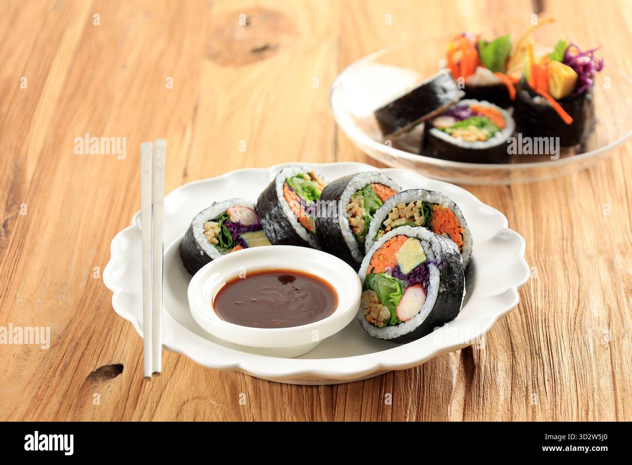 Gimbap alla coreana, di riso, carota, salsiccia, bastoncino di granchio, uova, torta di pesce e avvolta con le alghe marine. Servito con salsa piccante. Acceso Foto Stock