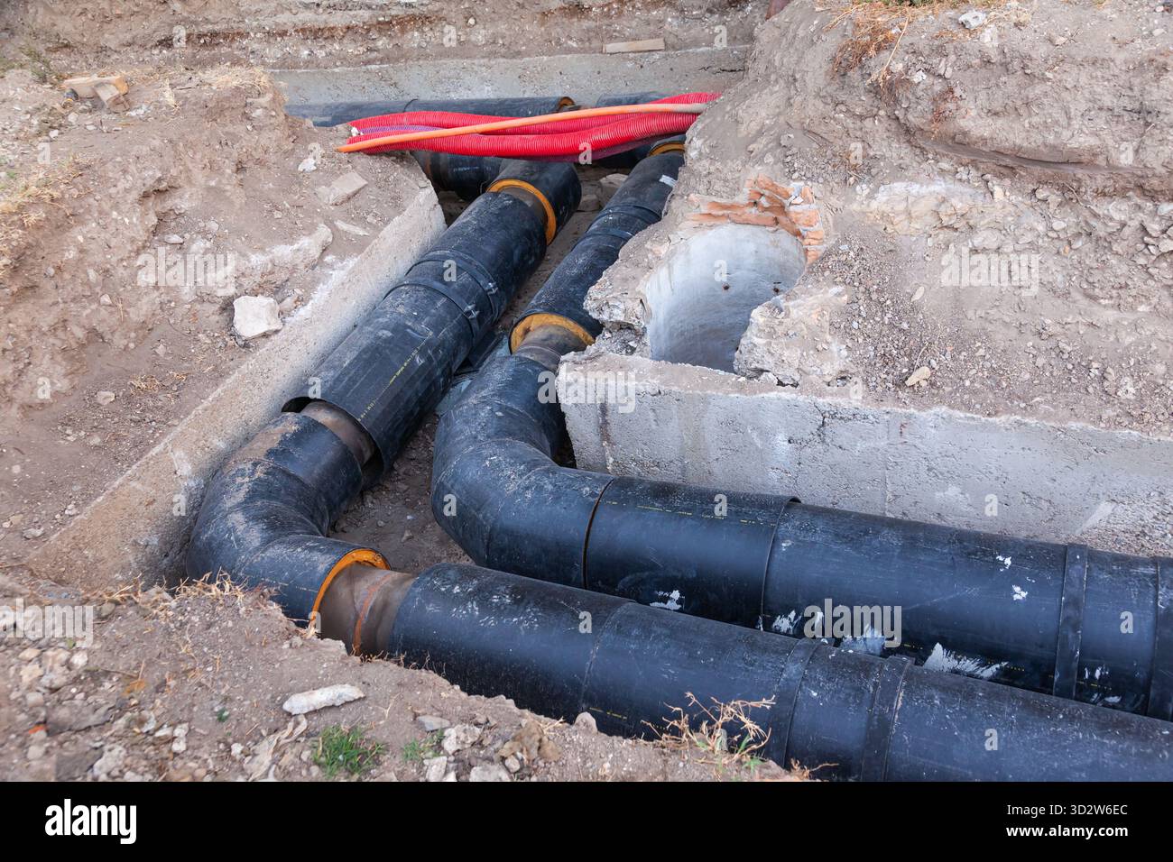Posa di nuovi tubi dell'acqua di grande diametro nel terreno della città. Foto Stock