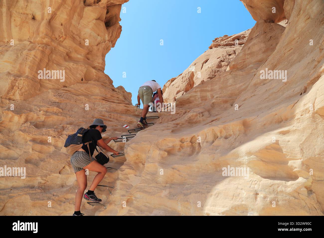 ELIFAZ, ISRAELE - 22 SETTEMBRE 2017: Persone non identificate salgono un ripido pendio di roccia erosa verso un arco roccioso nella riserva naturale nazionale di Timna i Foto Stock