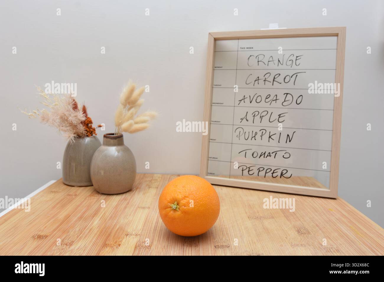 Una tavola e un'arancia indicano quale frutta mangiare il lunedì Foto Stock