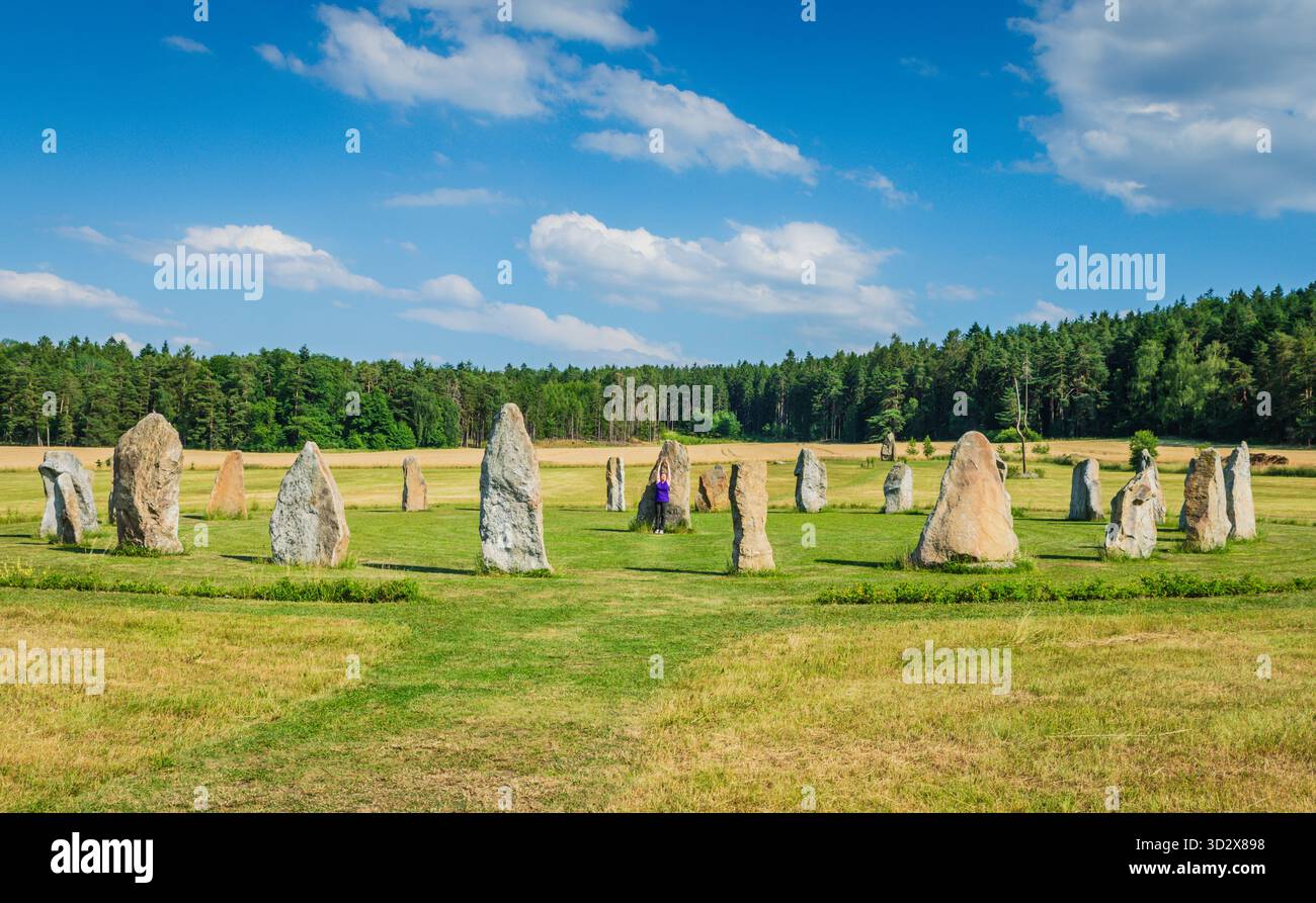 Holašovice, Cechia - 2 luglio 2019: Donna canalizzante l'energia del cerchio di pietra di Holasovice, una riproduzione di Stonehenge. Foto Stock