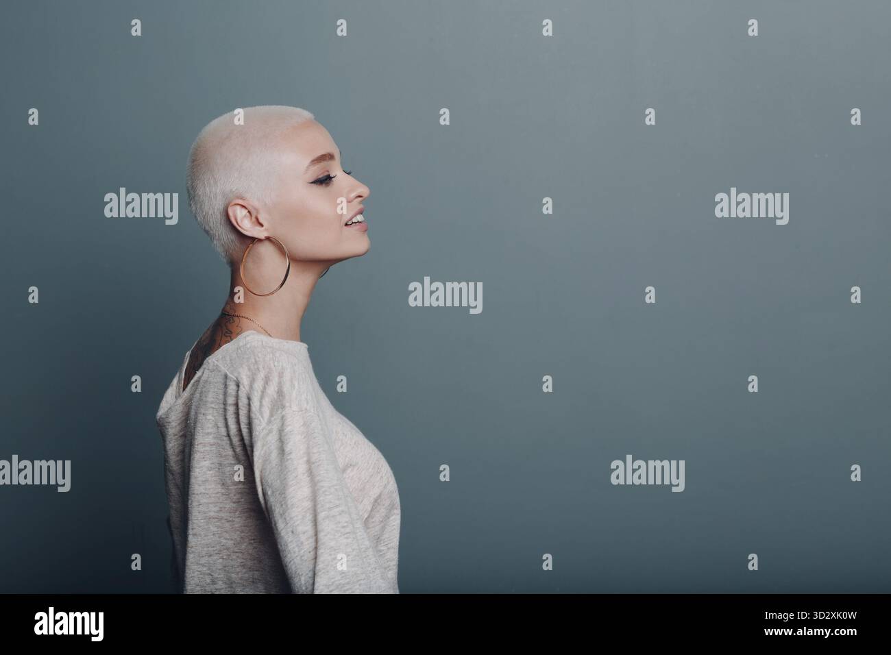 Giovane donna milleniale con capelli biondi corti profilo ritratto sognando Foto Stock
