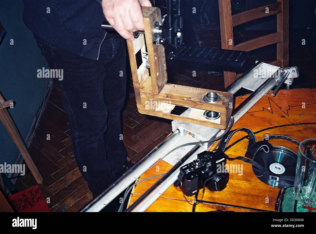 Prototipo in legno della testa di una telecamera per il controllo del movimento su binari, tenuto da un ingegnere, catturato in stile pellicola analogica per la documentazione di archivio. Foto Stock