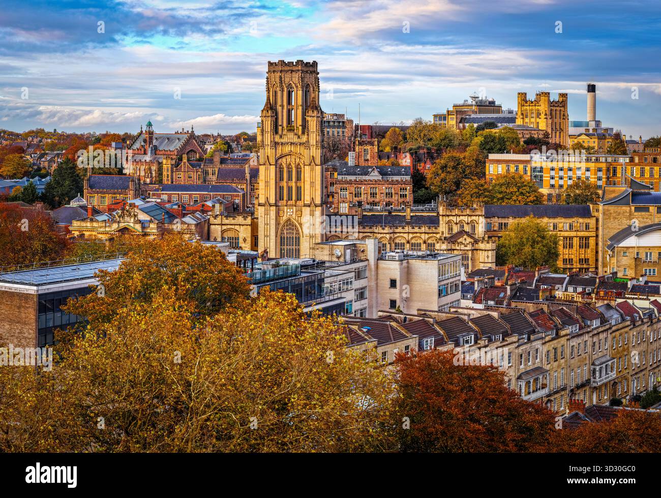 Vista del Wills Memorial Building dell'Università di Bristol circondato dall'architettura storica della città e dagli alberi autunnali sotto un cielo vivace. Foto Stock